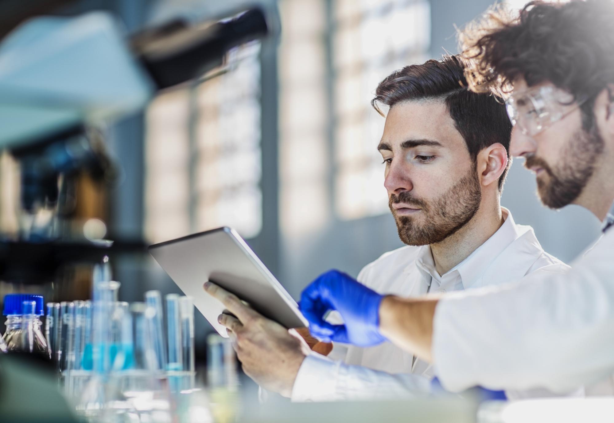 Two scientists using a tablet