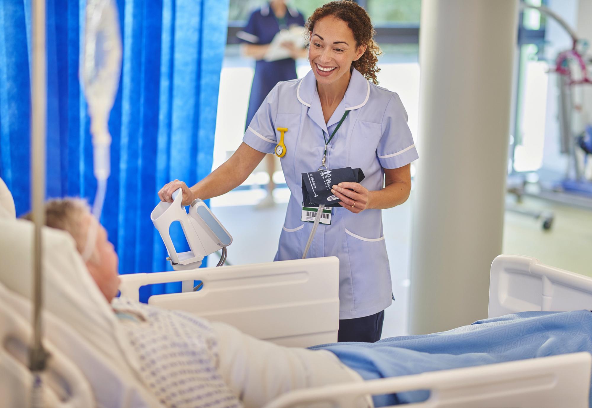 nurse chatting to patient on hospital ward