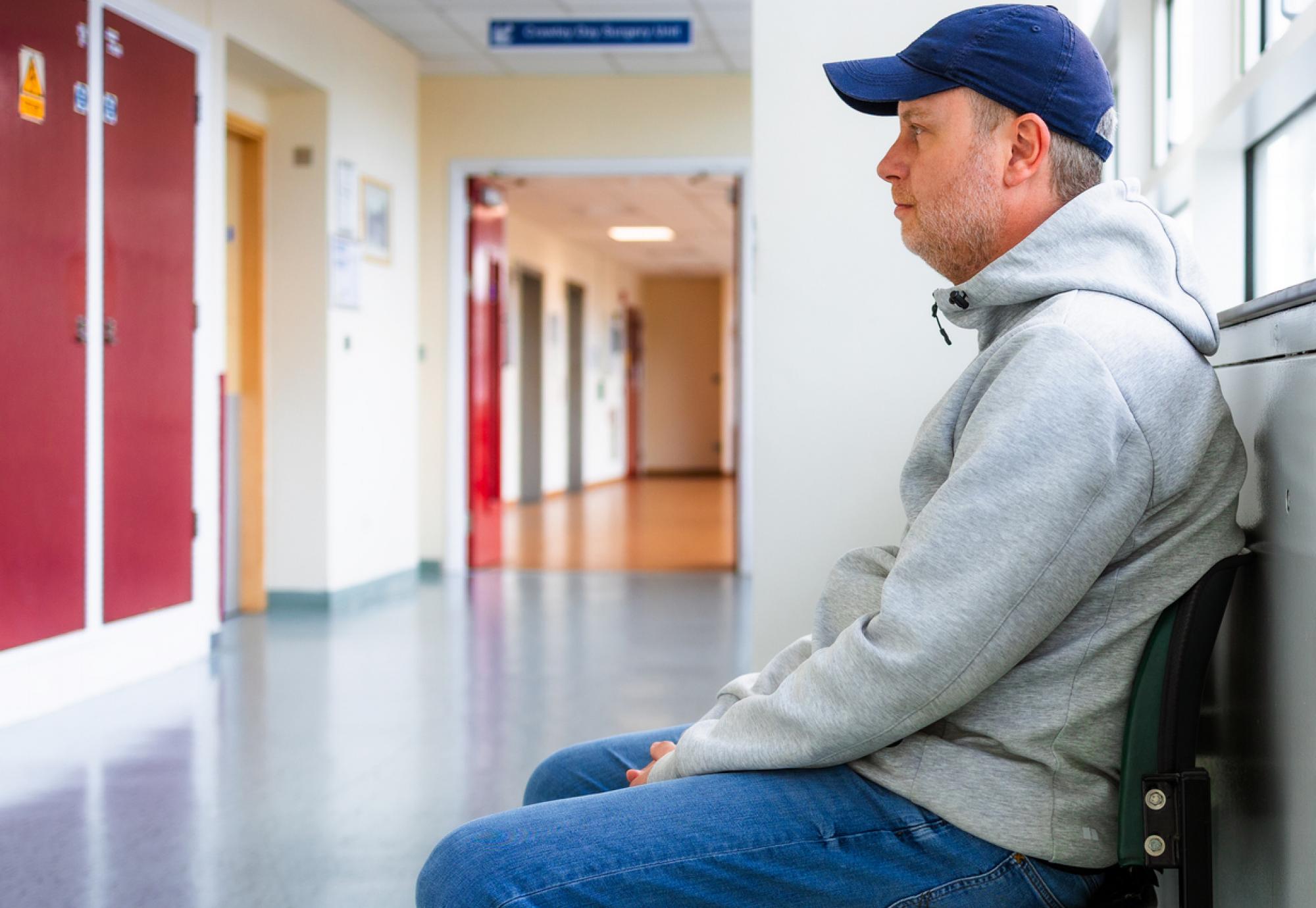 Man sat in a hospital corridor