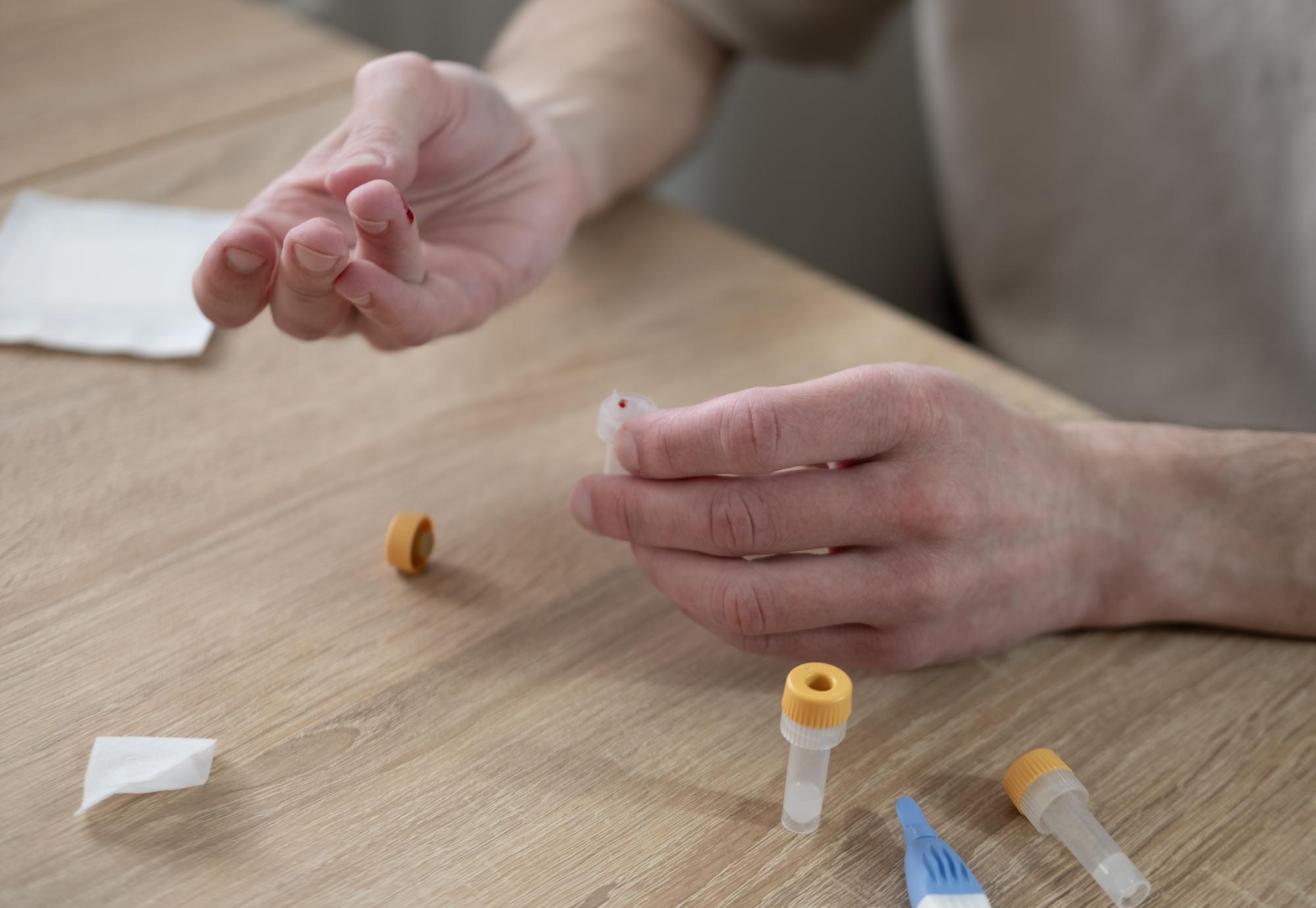 Man undertaking a finger-prick blood test