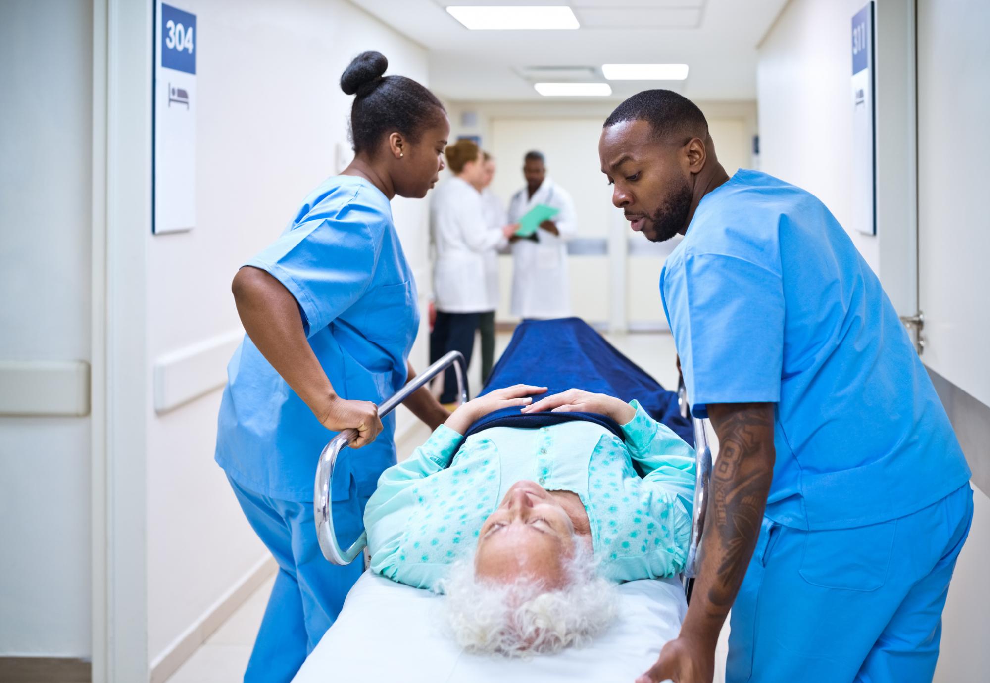 Nurses pushing woman on a hospital bed