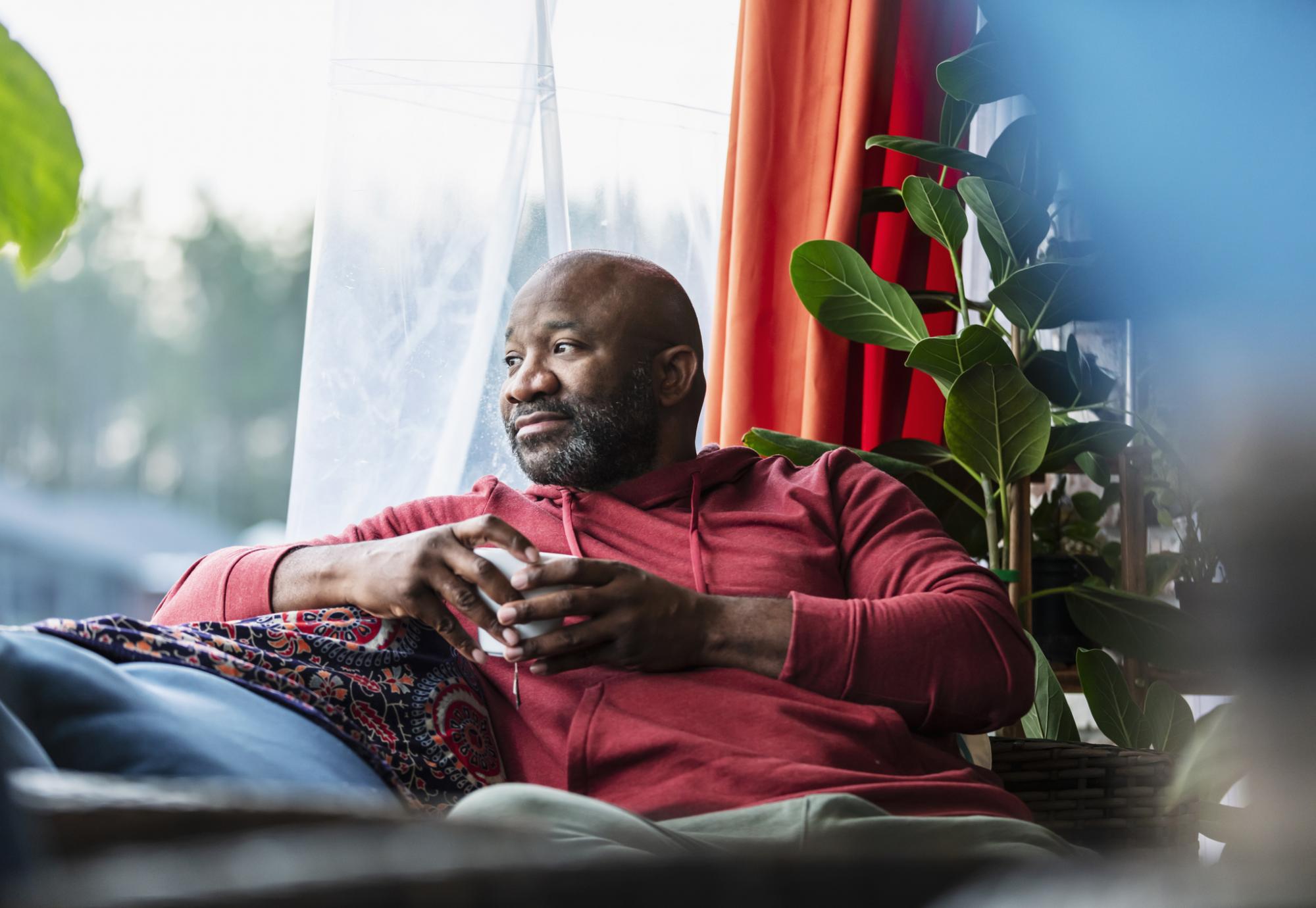 A black man sat on a sofa