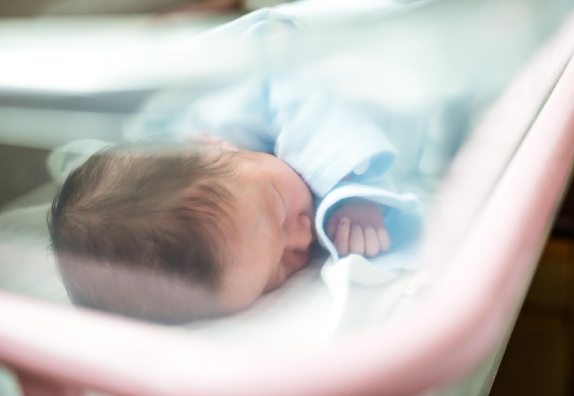 Newborn baby in hospital cot