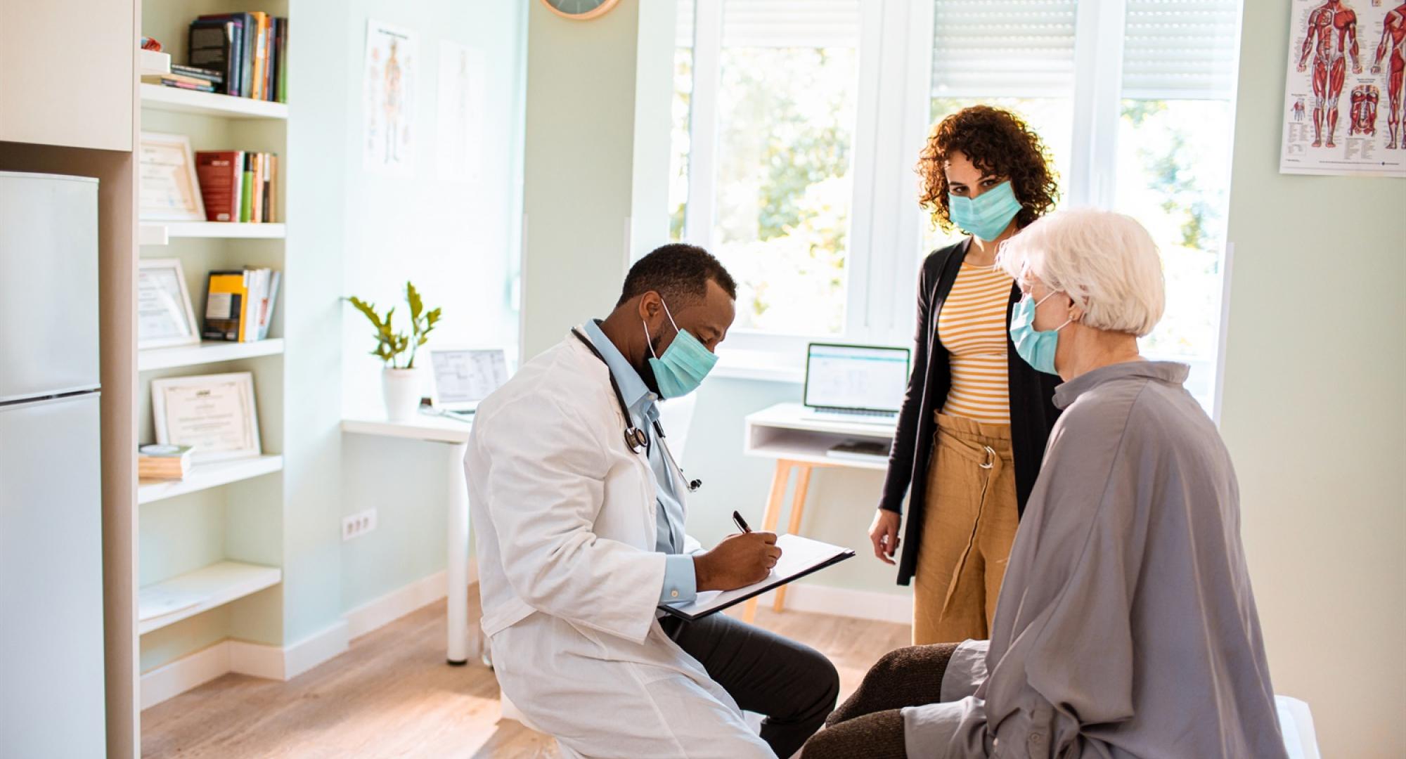 Male doctor discussing with two patients