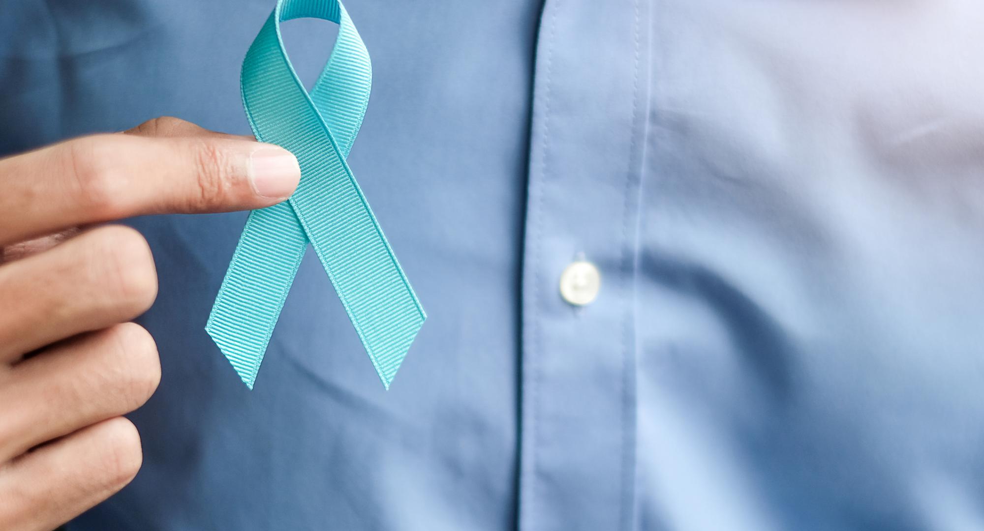 Man holding a blue prostate cancer ribbon