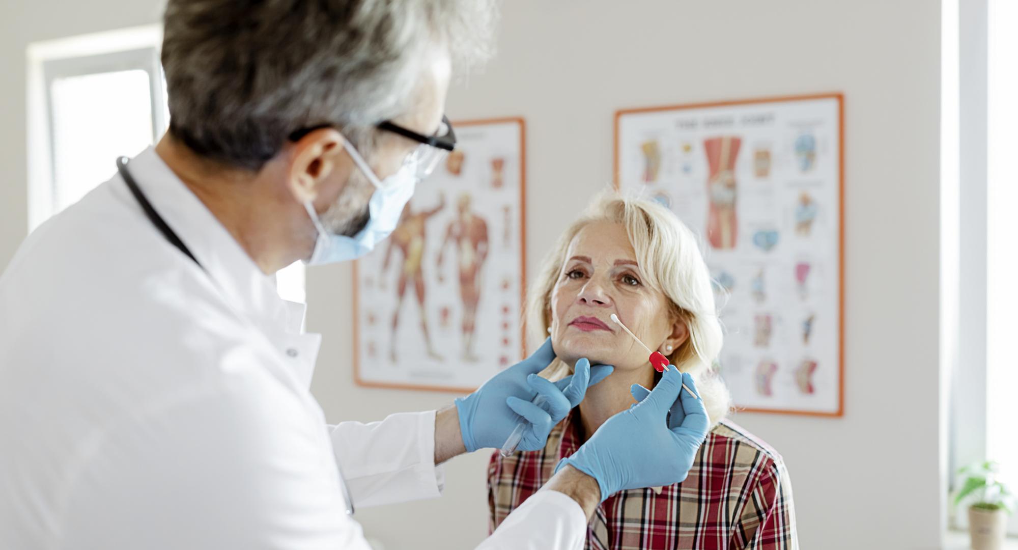 Male doctor performs a nasal swab on a patient