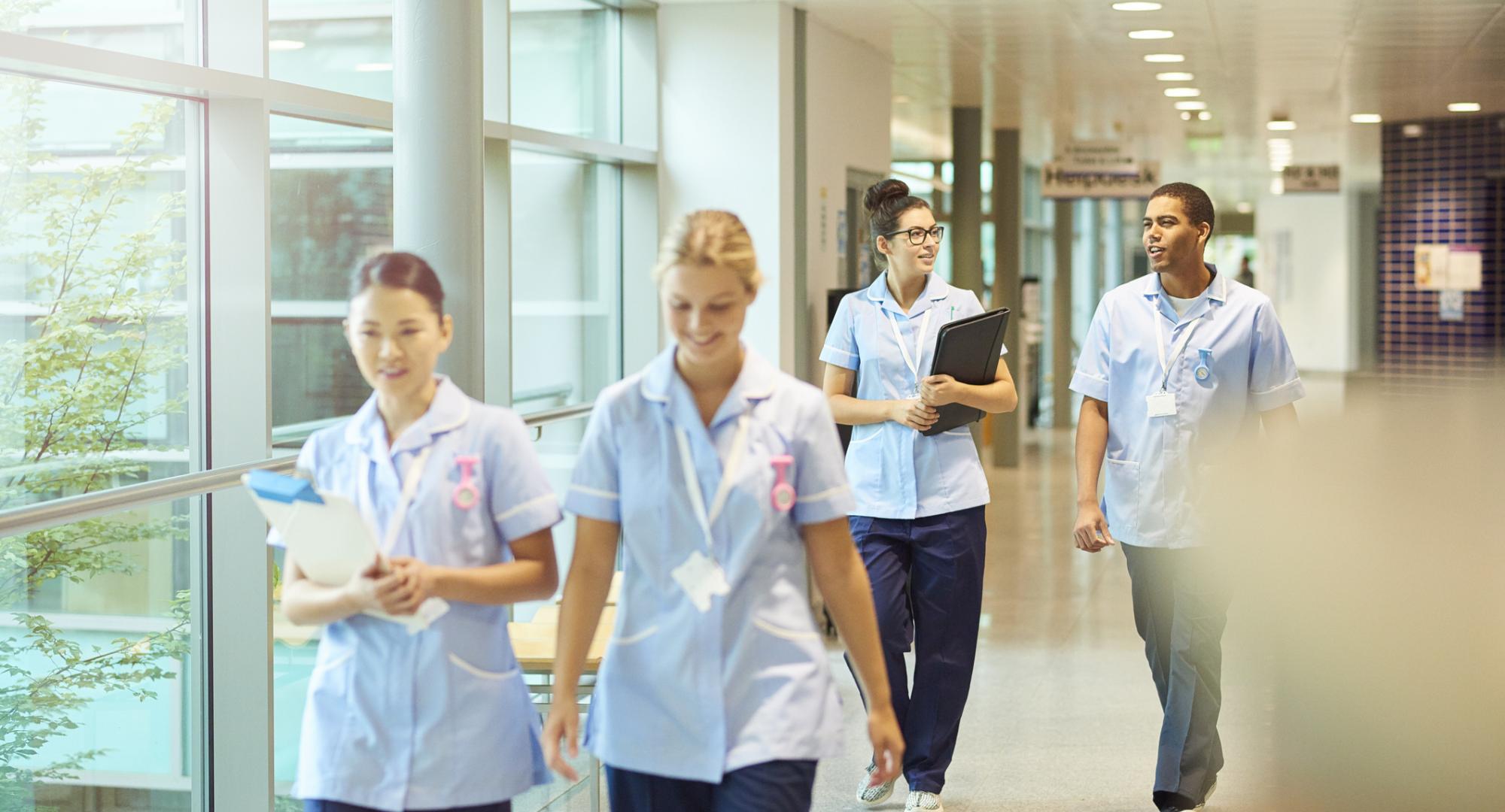 A group of nurses walking through a hospital corridor