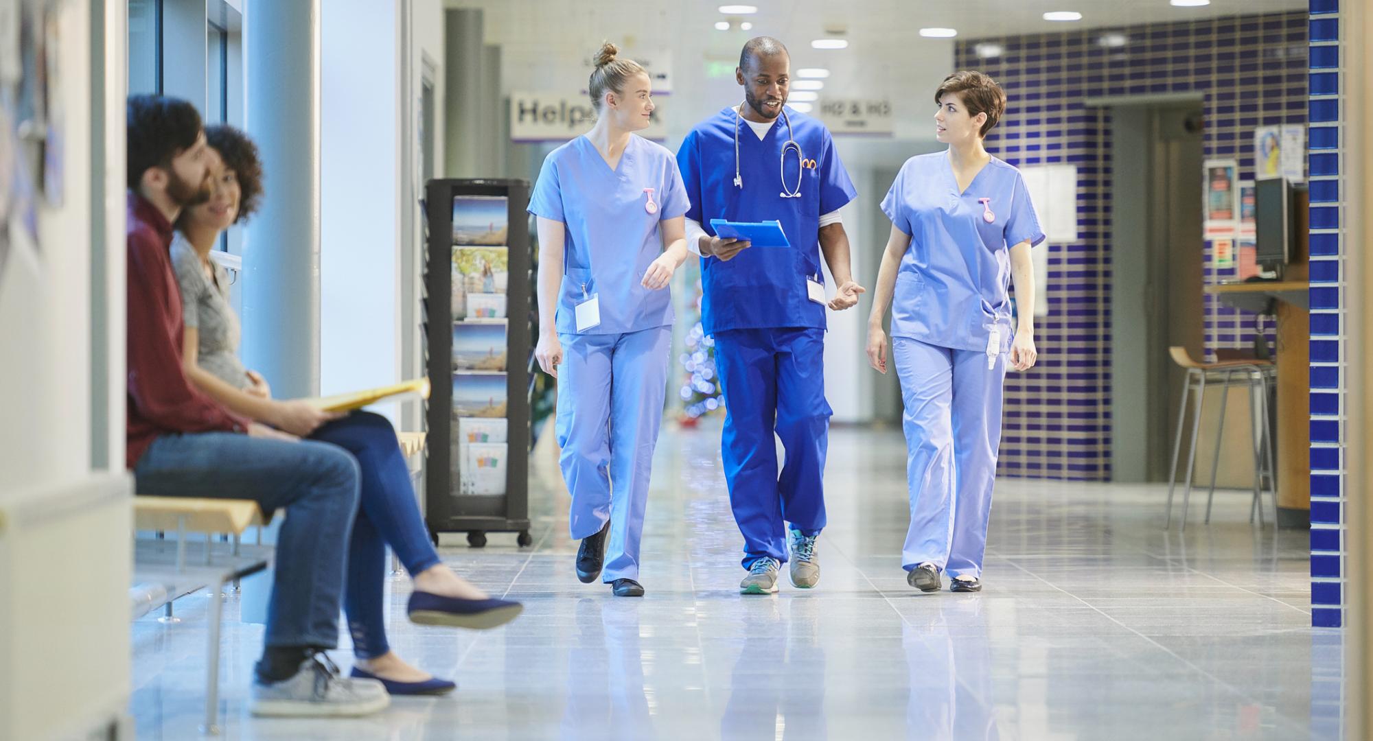 Nurses having a conversation walking through hospital corridors