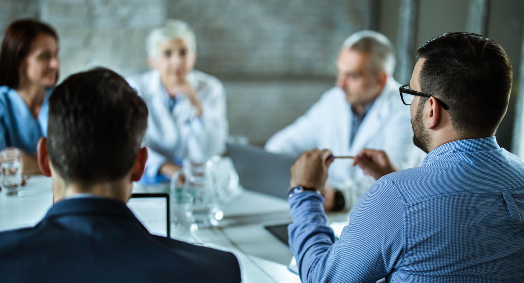 Health meeting discussing around a boardroom table