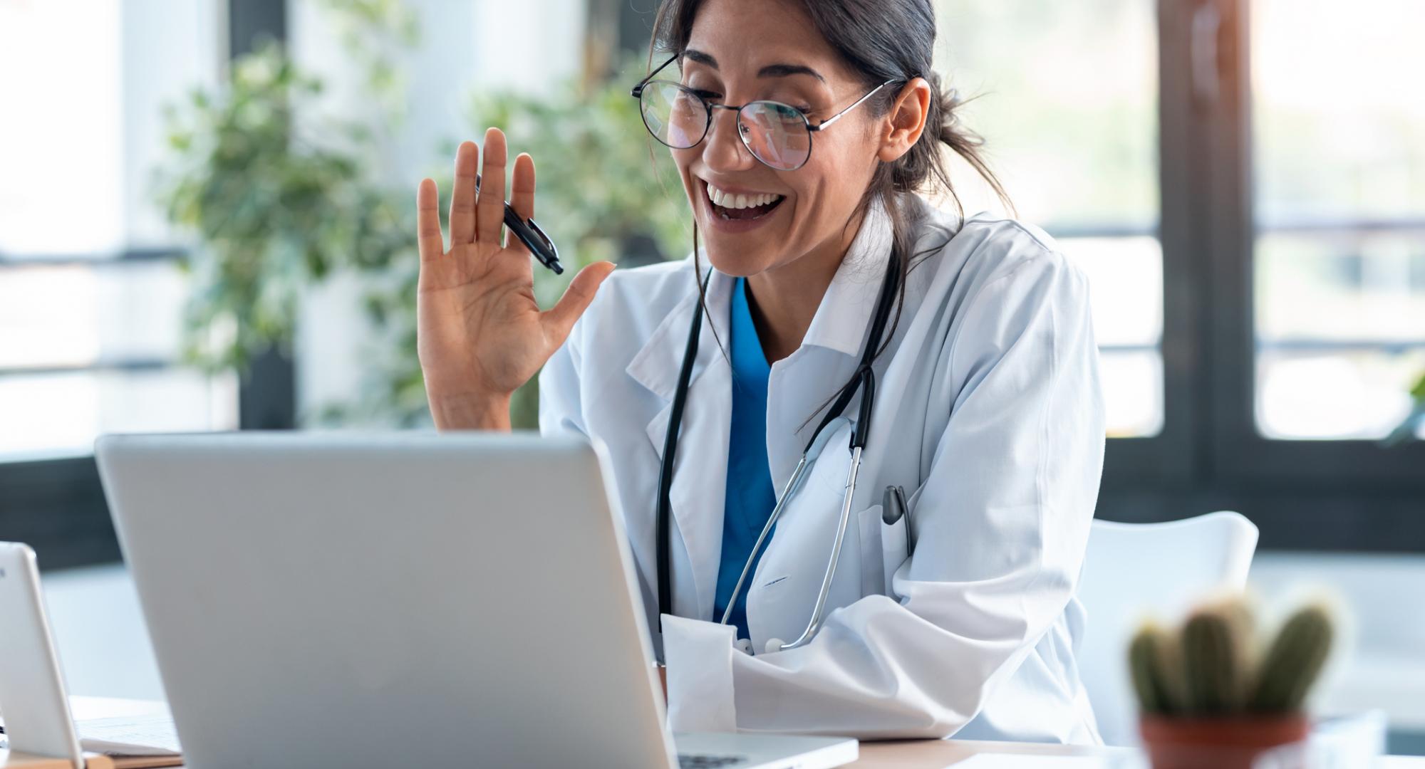 Doctor using a laptop to carry out virtual clinics