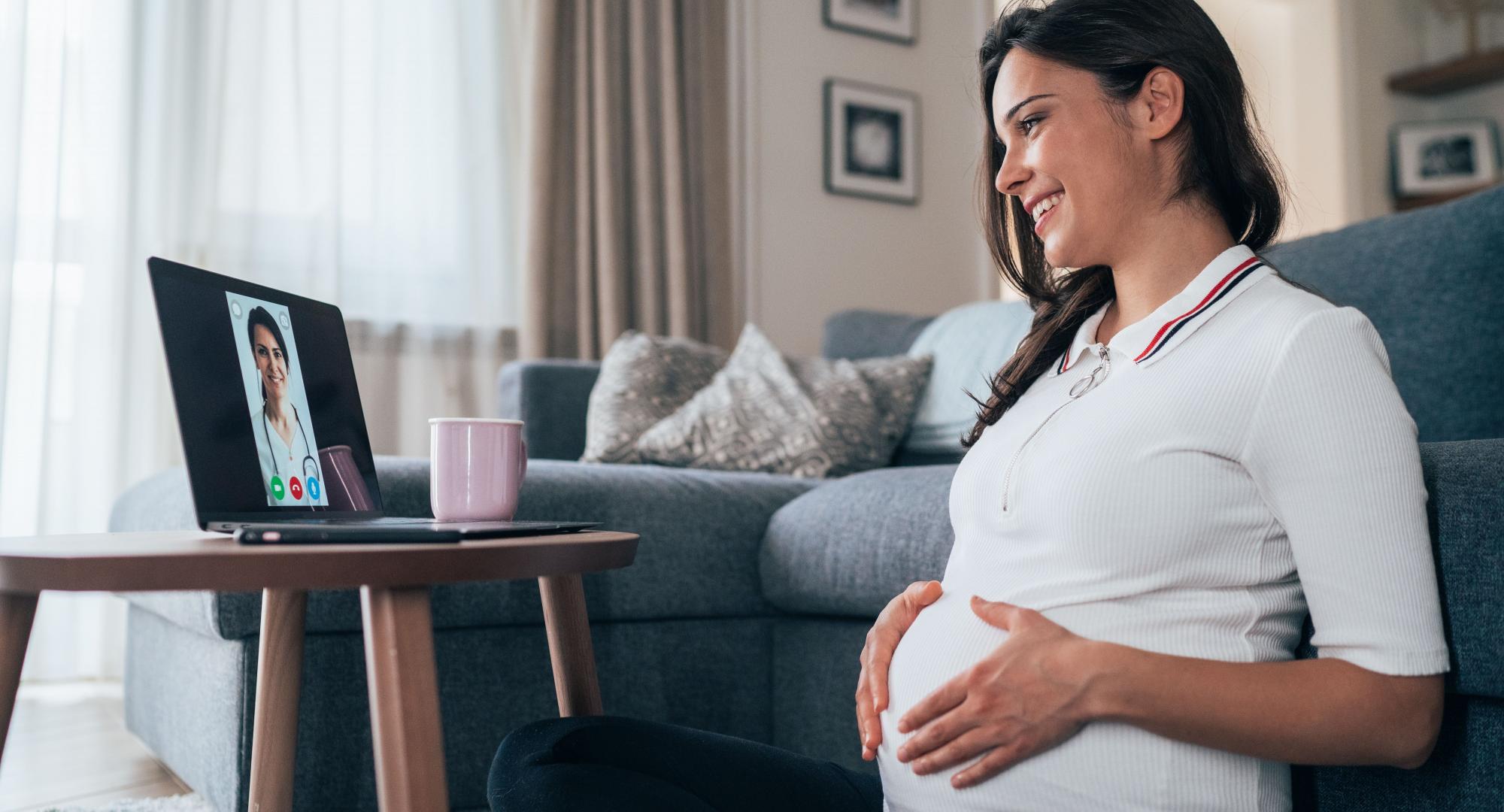 Pregnant woman talking remotely with a clinician