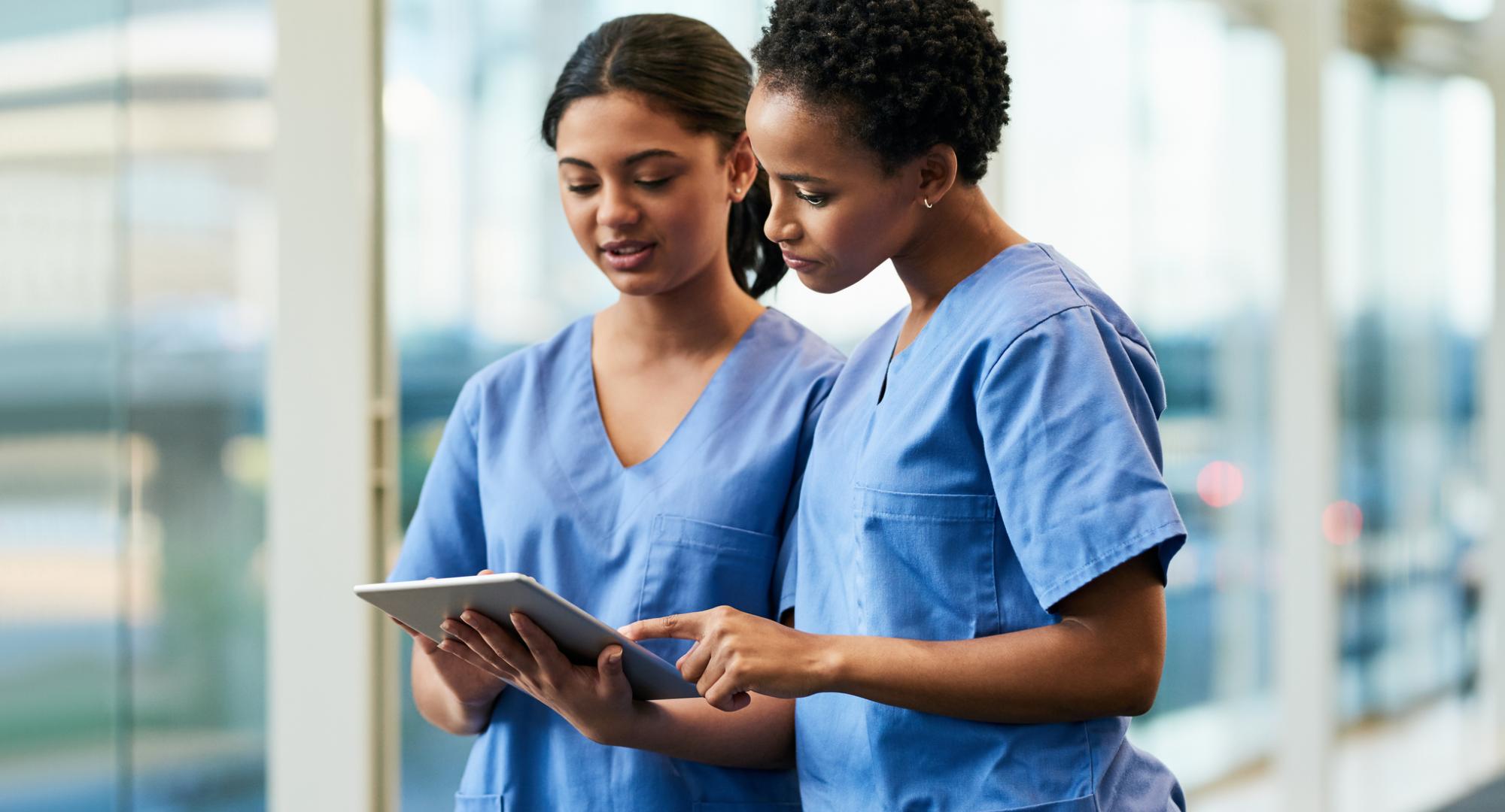 Nurses in conversation looking at a tablet PC