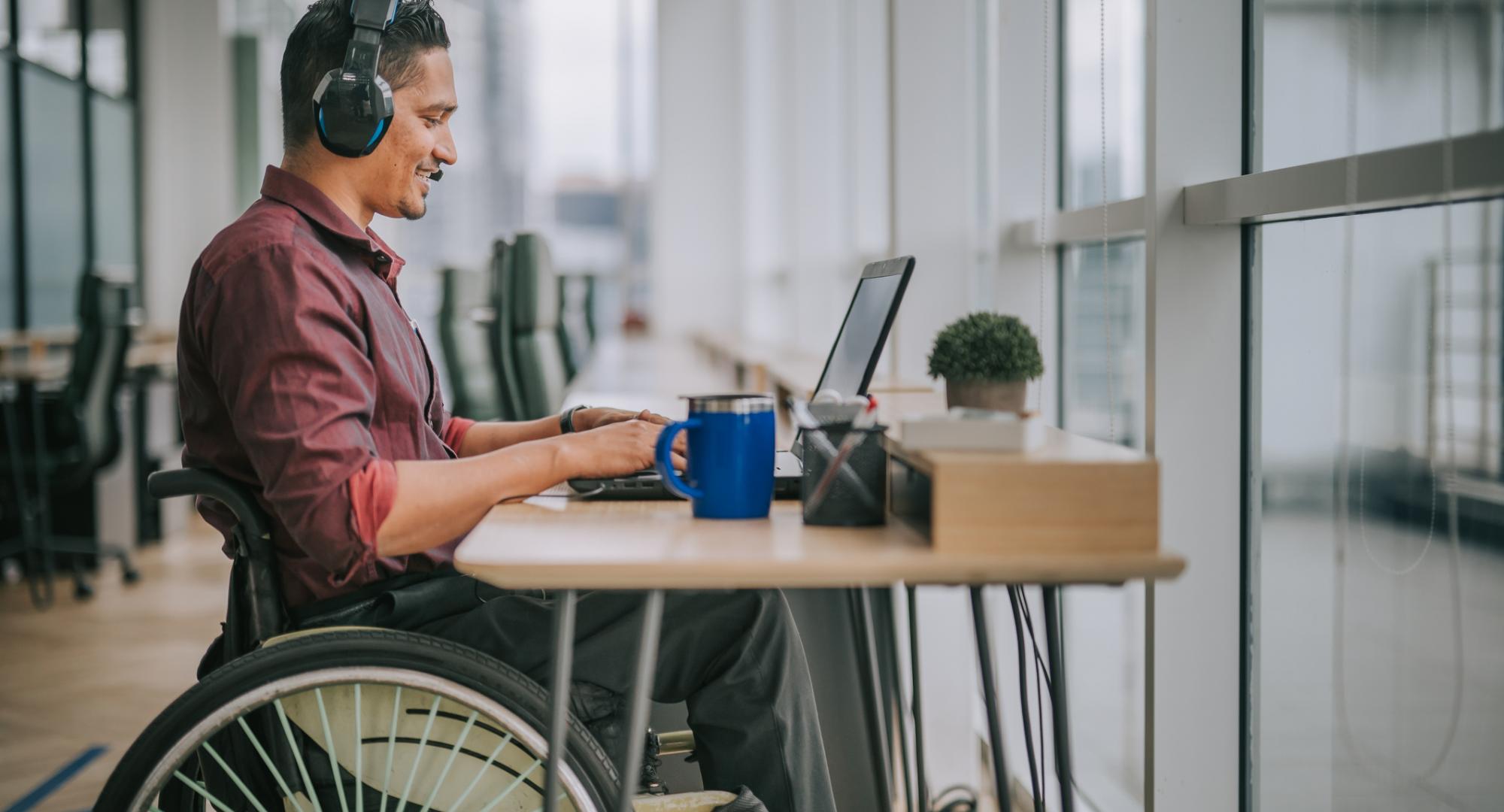 Employee in a wheelchair using a computer at his desk