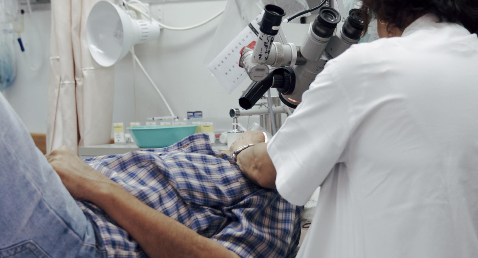 Doctor looking at patient through microscope