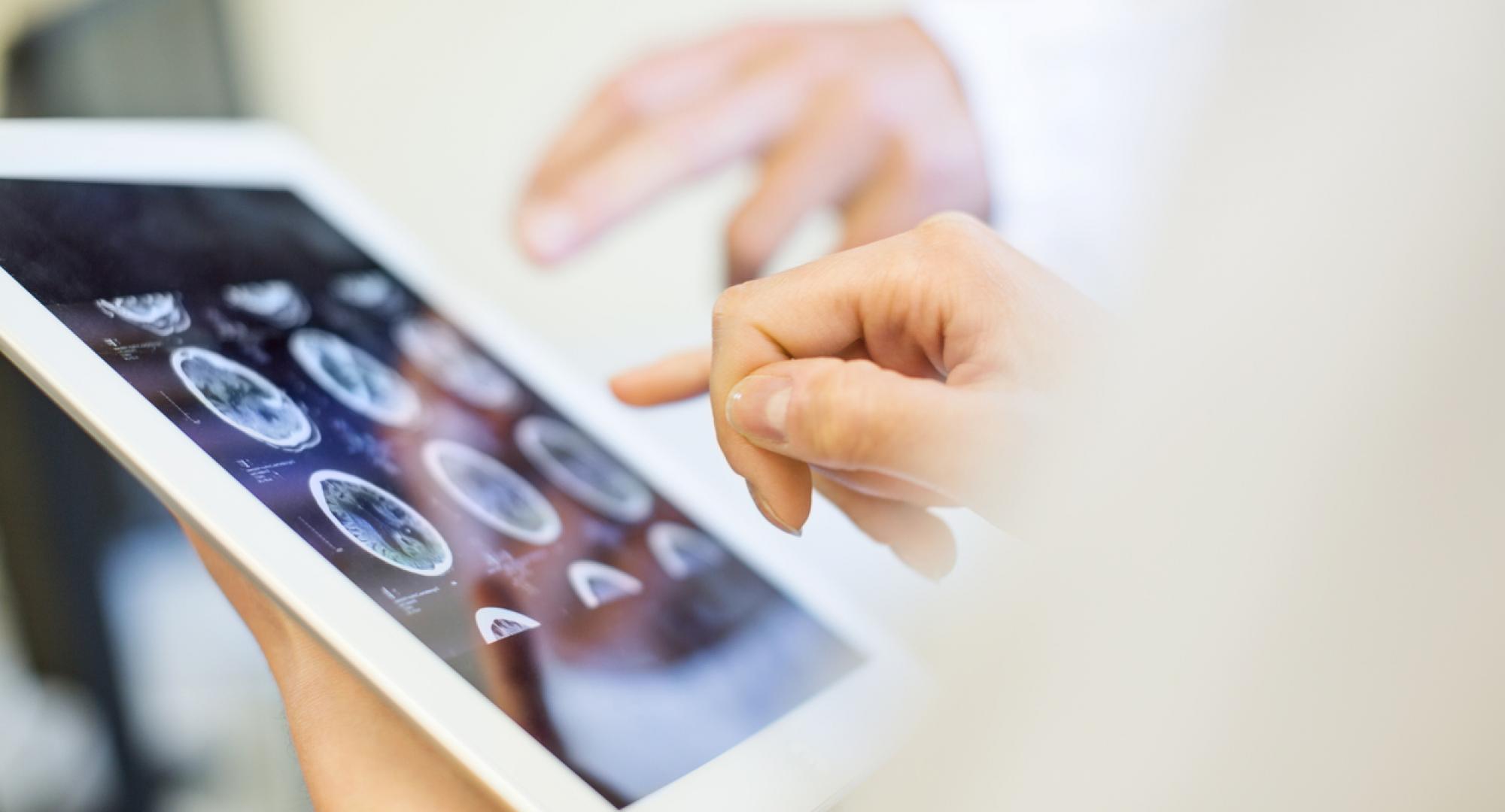 Medical team analysing MRI scans on digital tablet