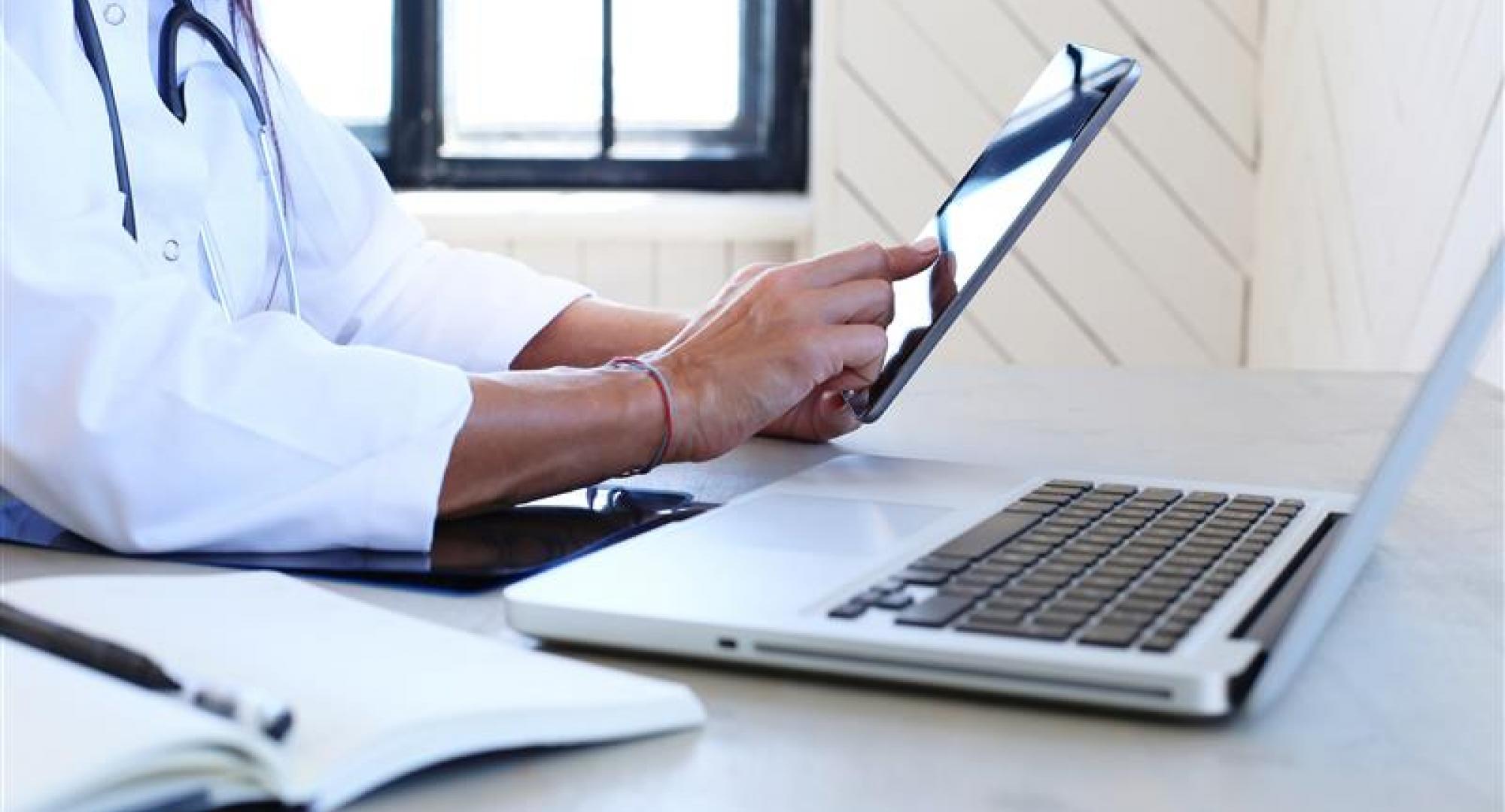 Person using laptop and digital tablet