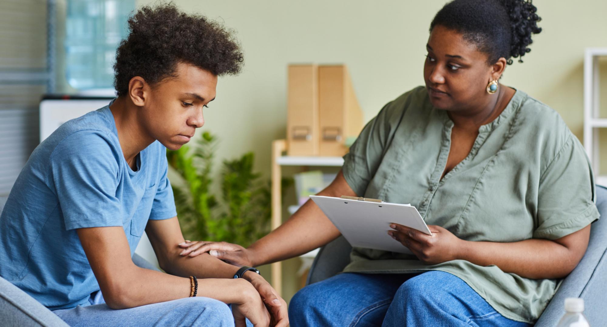 Psychologist with young boy in an office