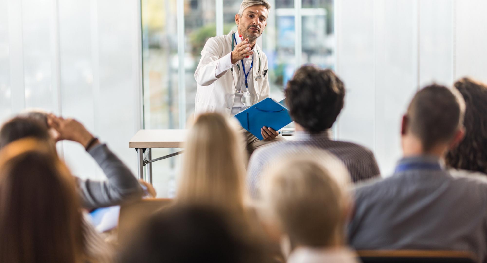 Health professional teaching students in a board room