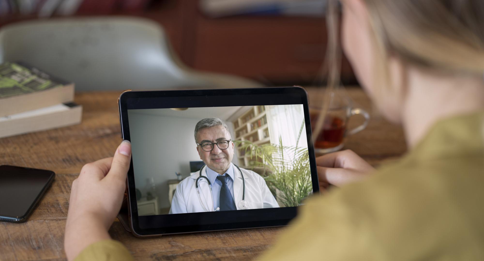 Doctor and patient talking on video call using digital tablet