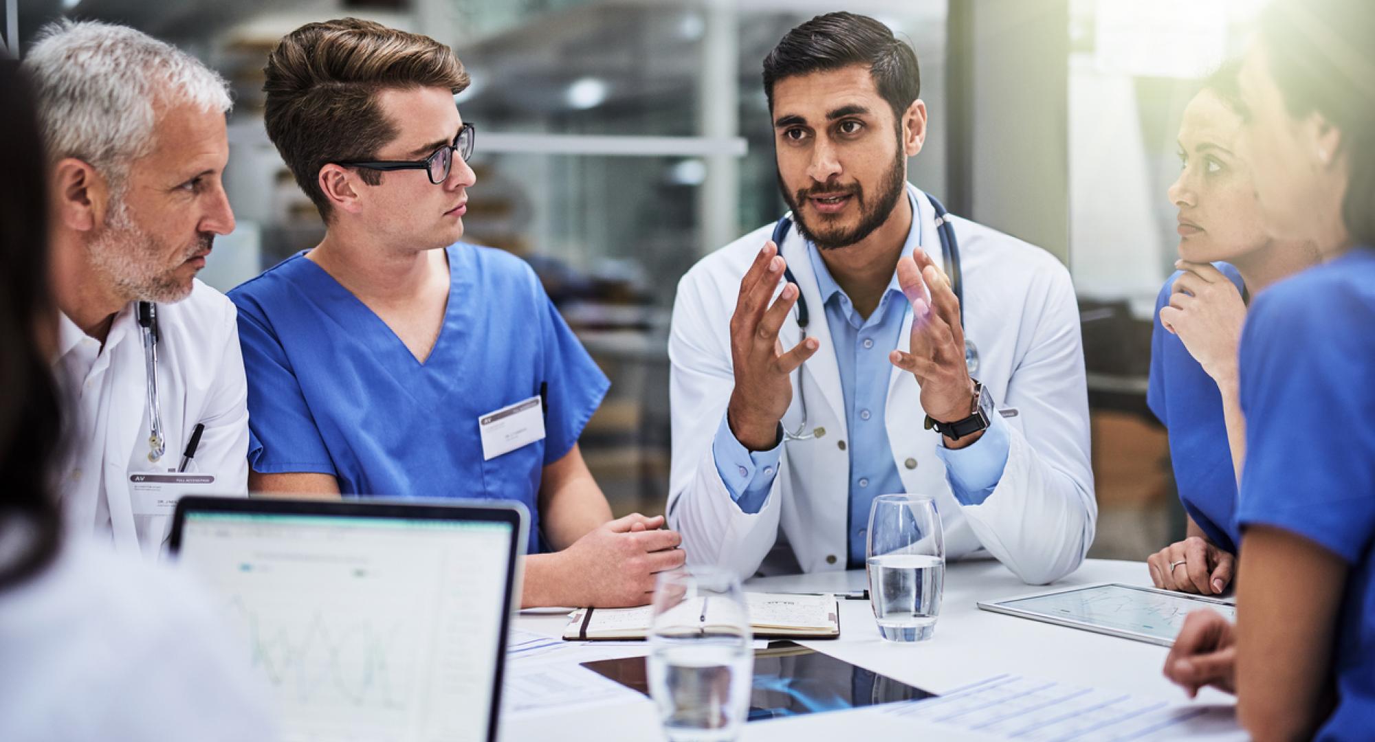 Group of health professionals talking around a table