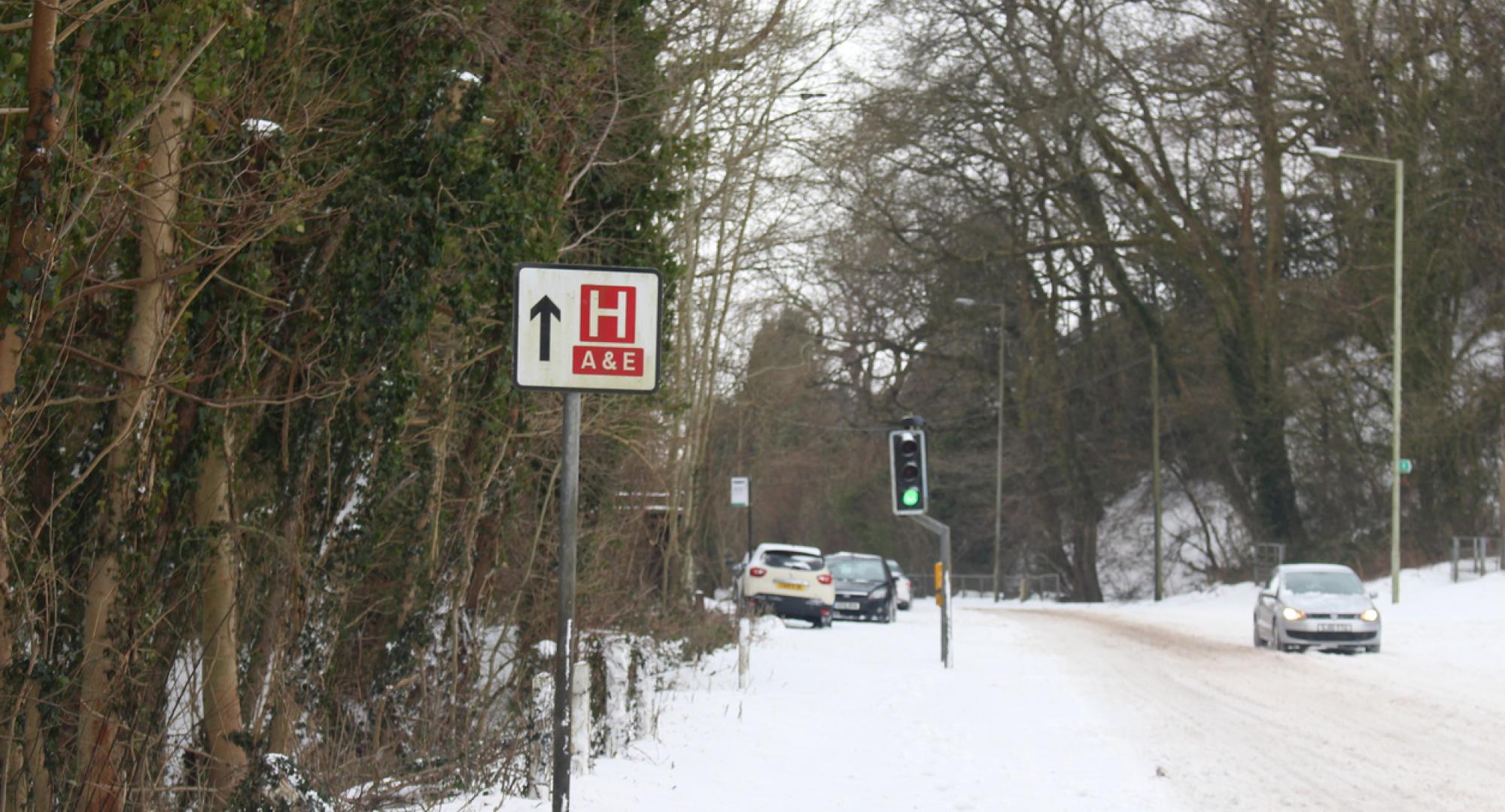 Hospital sign on a snowy road depicting NHS winter pressures