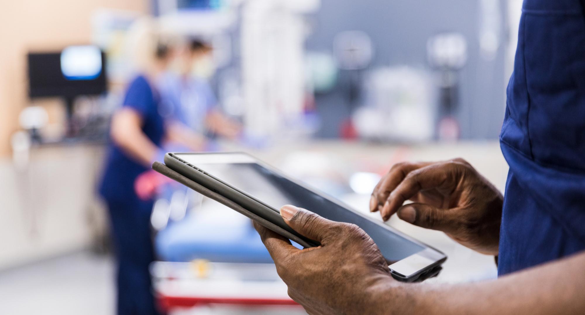 Health professional holding a tablet depicting digital transformation