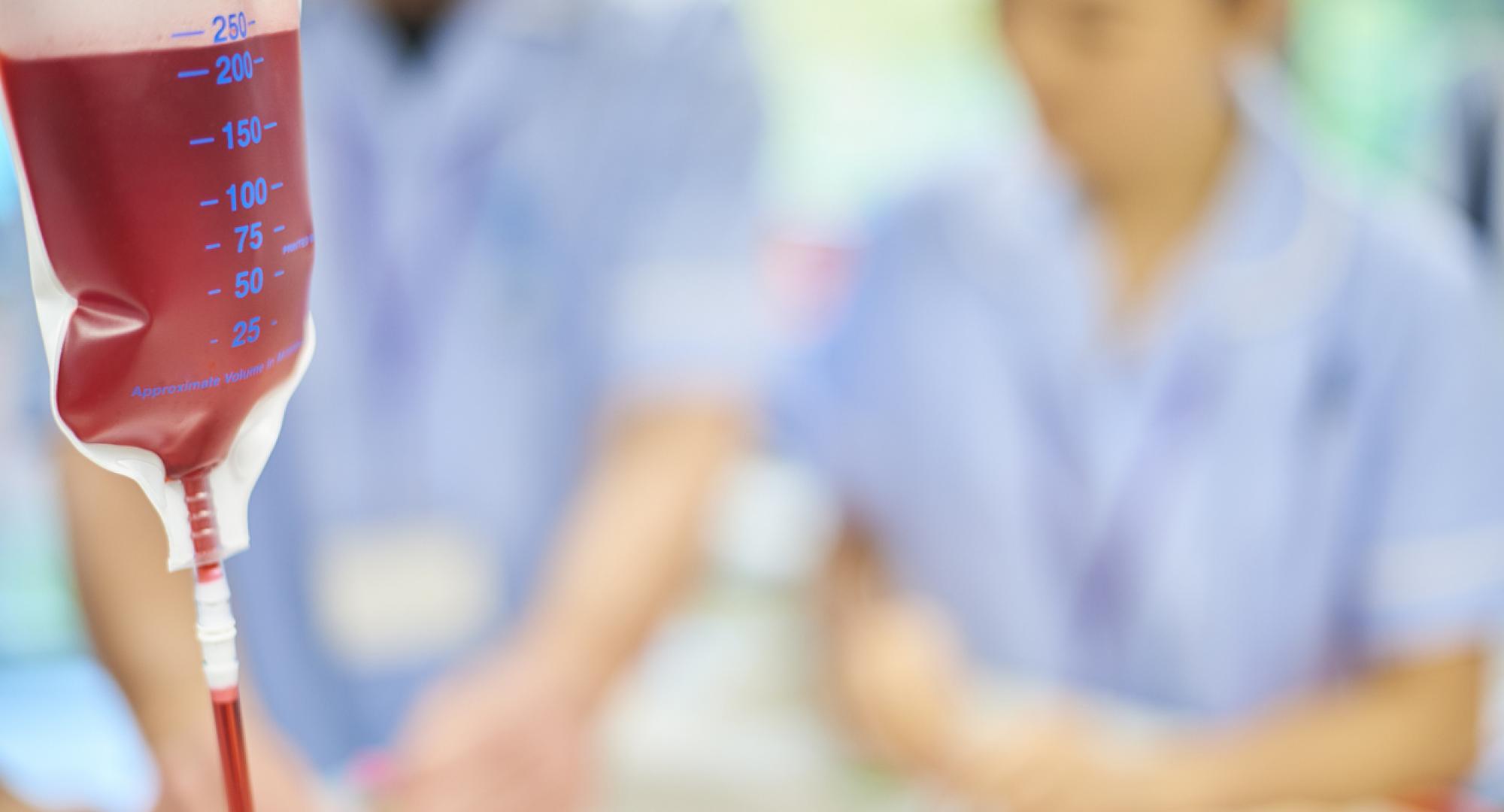 A blood bag with nurses in the background