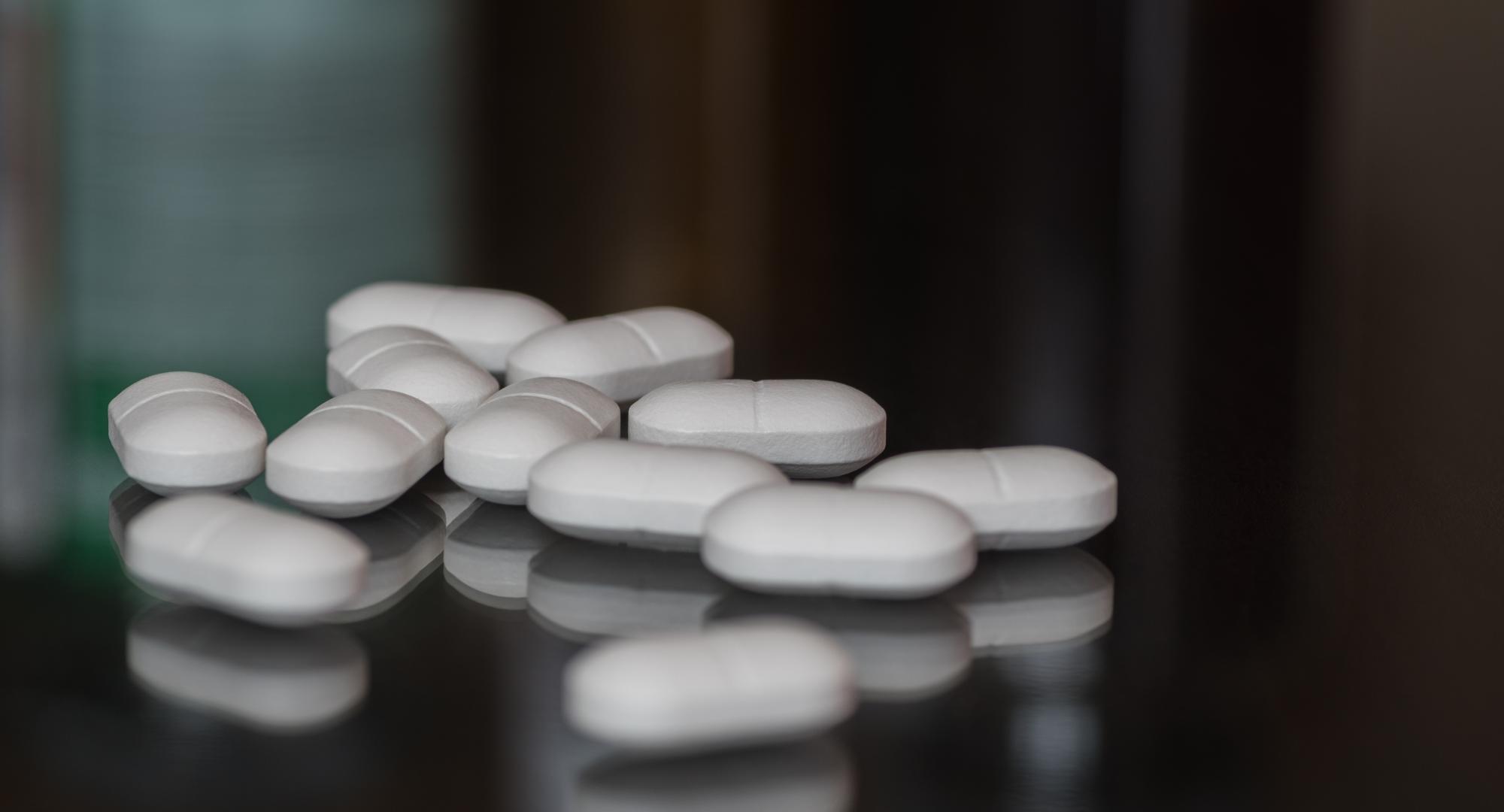 White pills on a dark surface