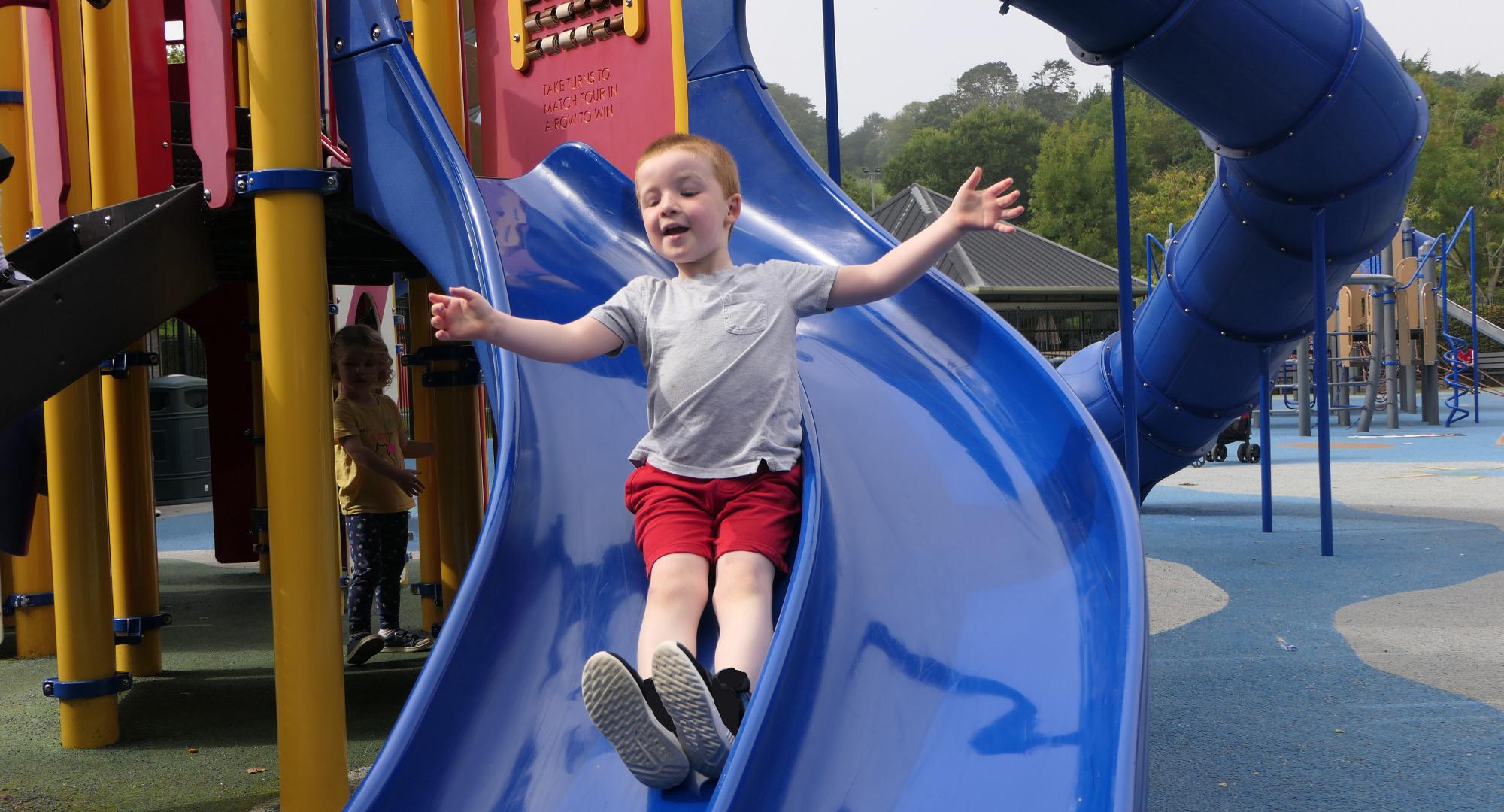 Young child playing on slide
