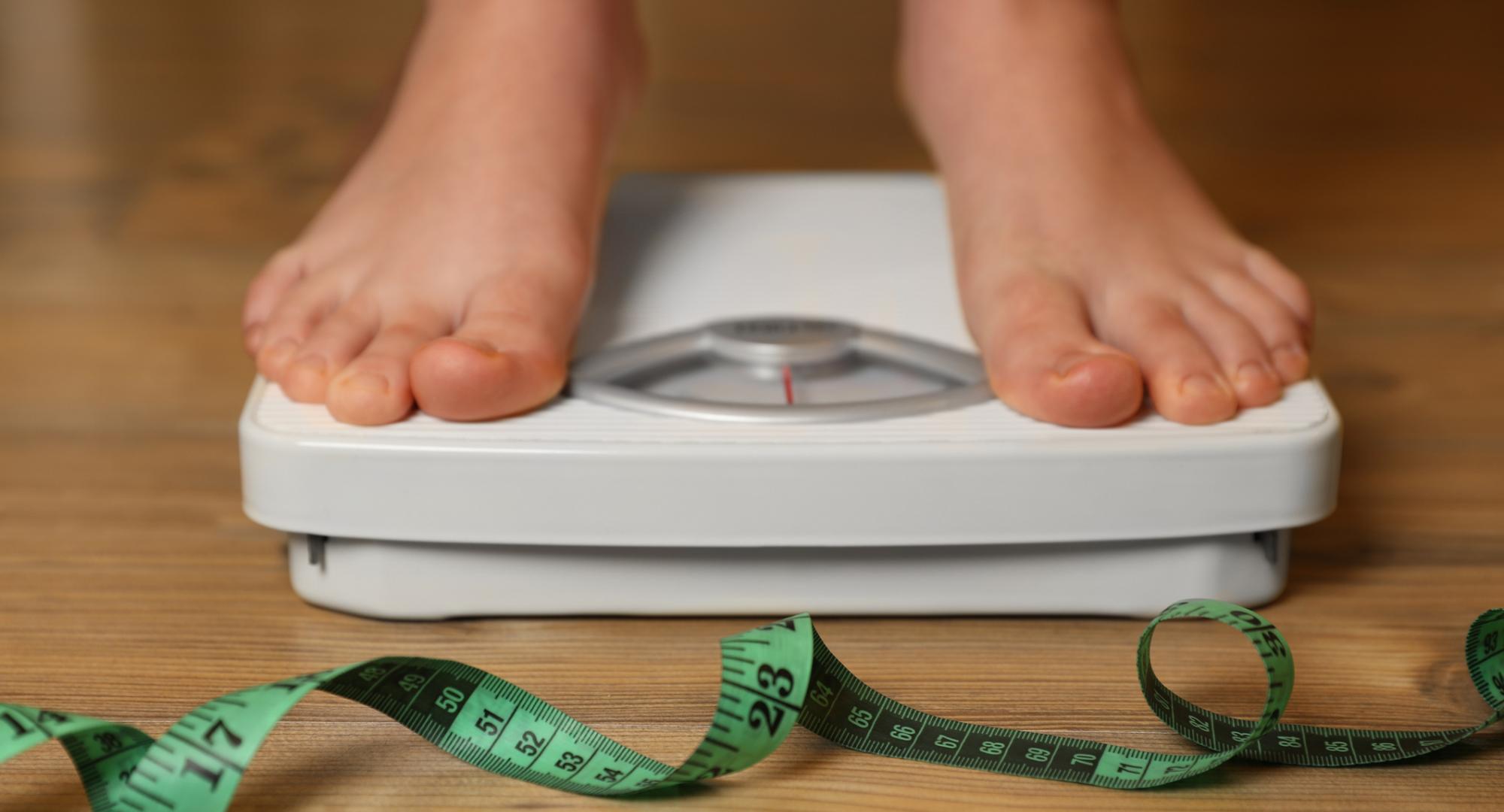 Overweight person using scales