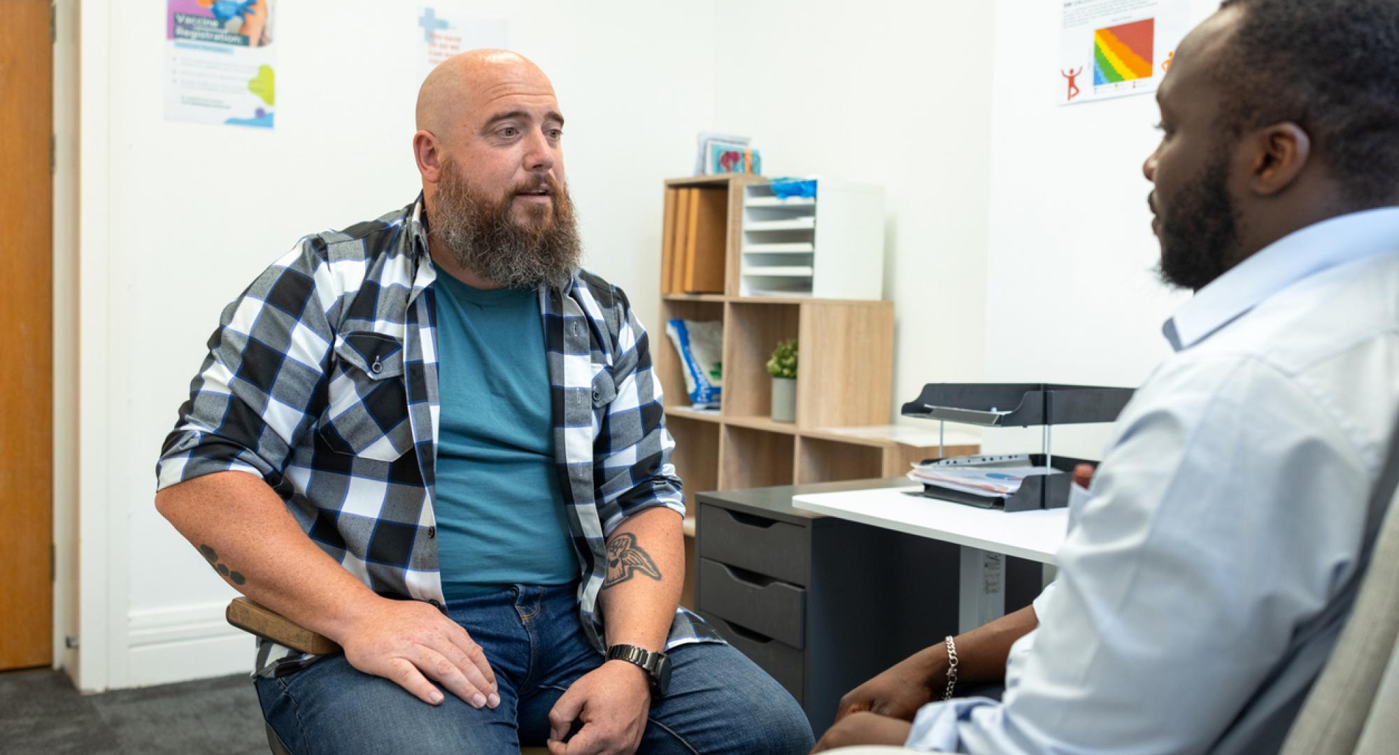 doctor sitting down with a male patient