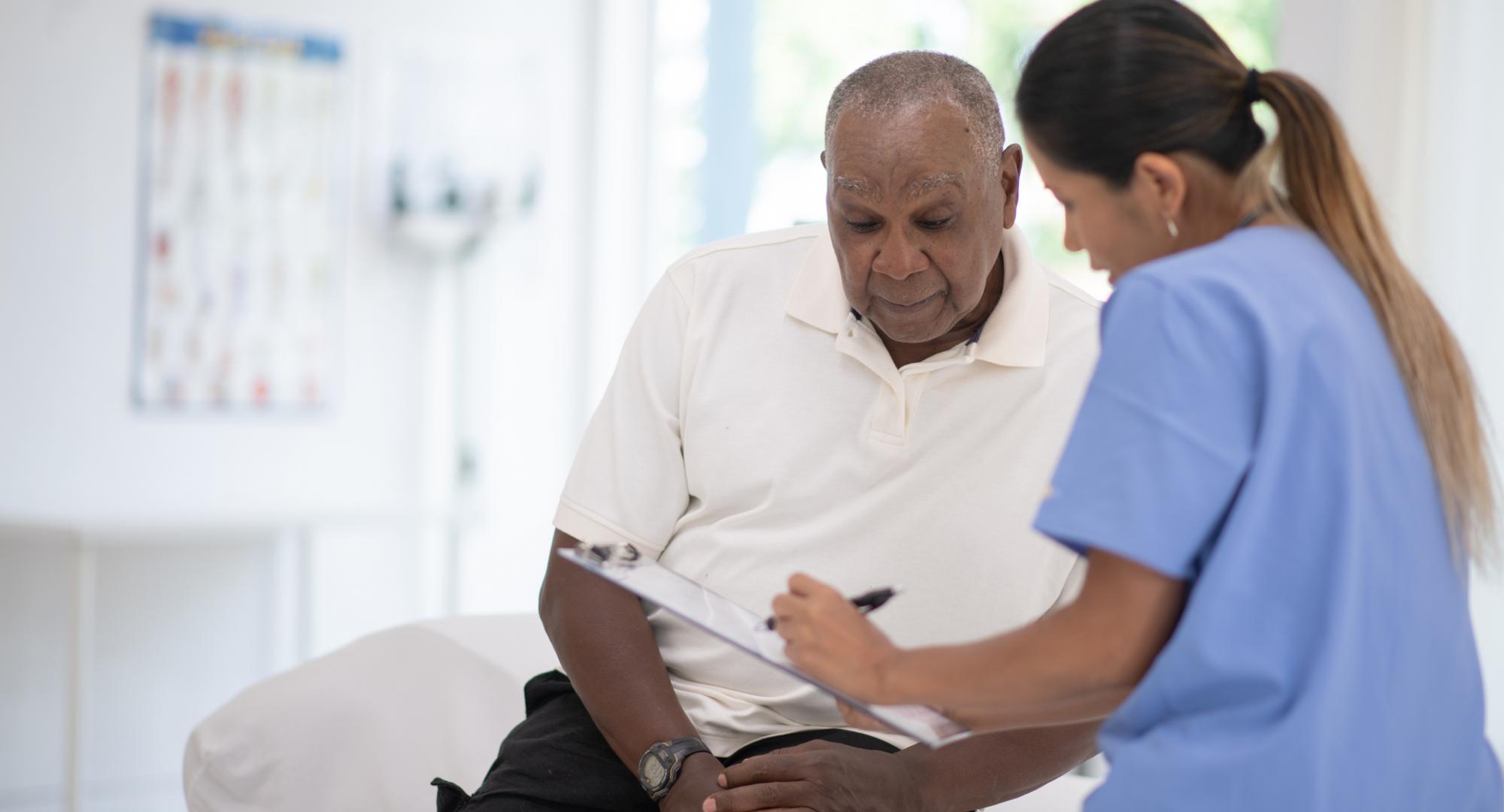 An older gentleman talks to a nurse about prostate cancer