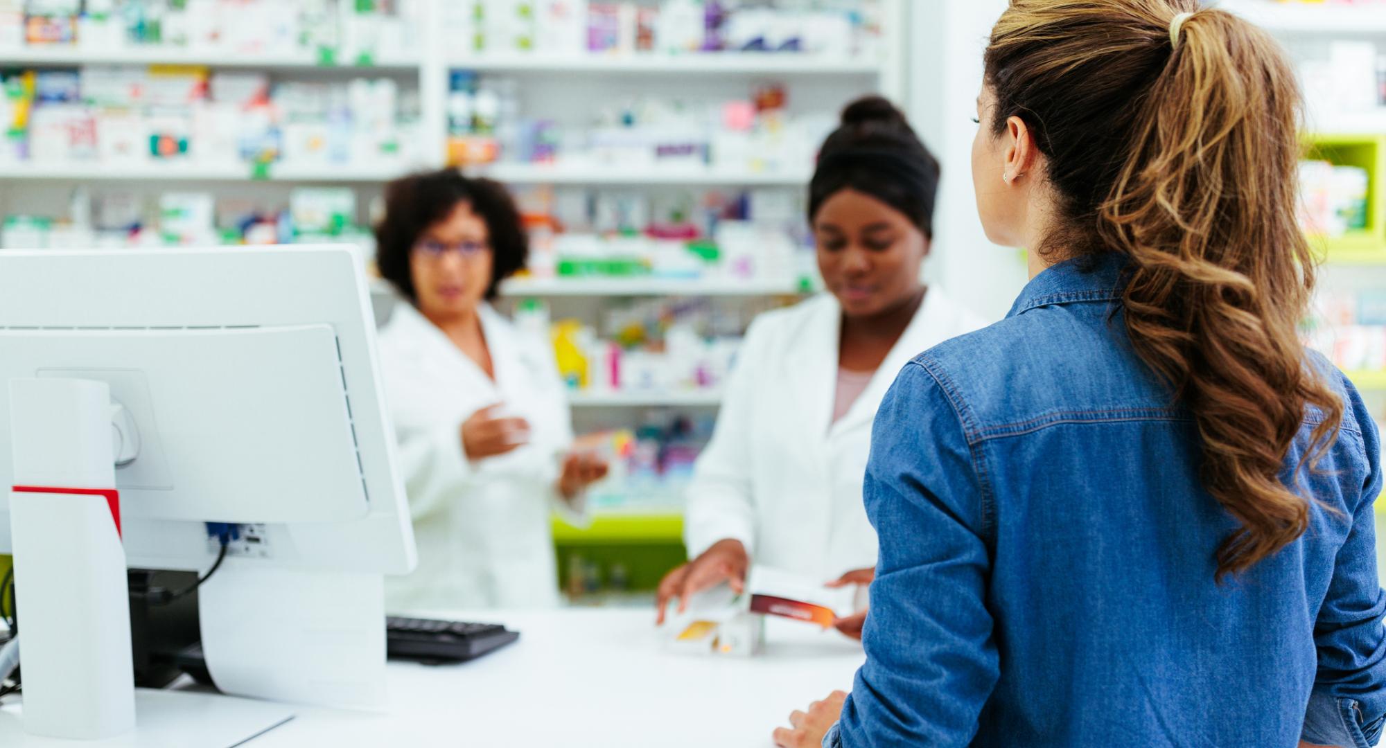 Young woman talking to pharmacists