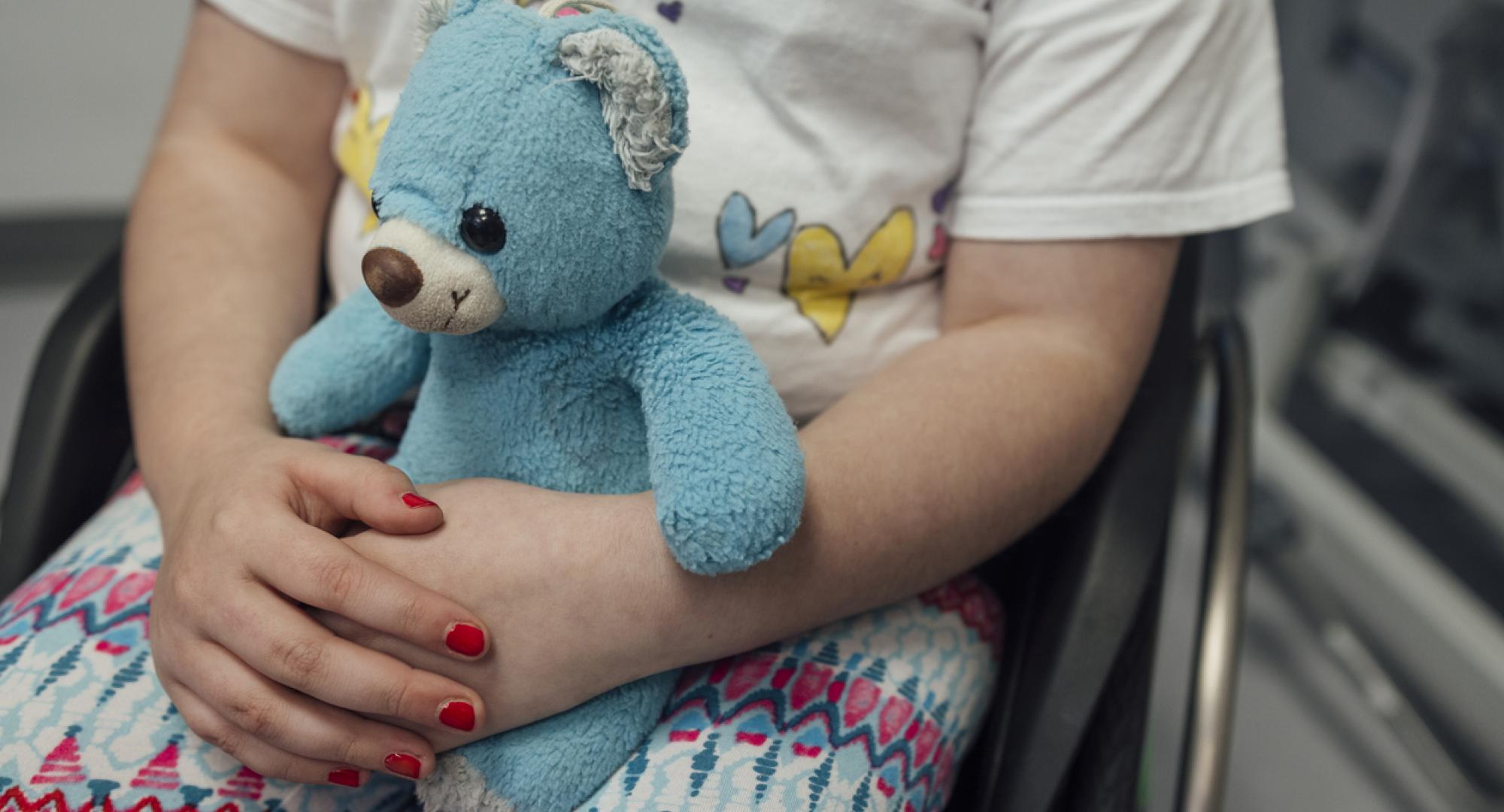 Small child holding a teddy bear