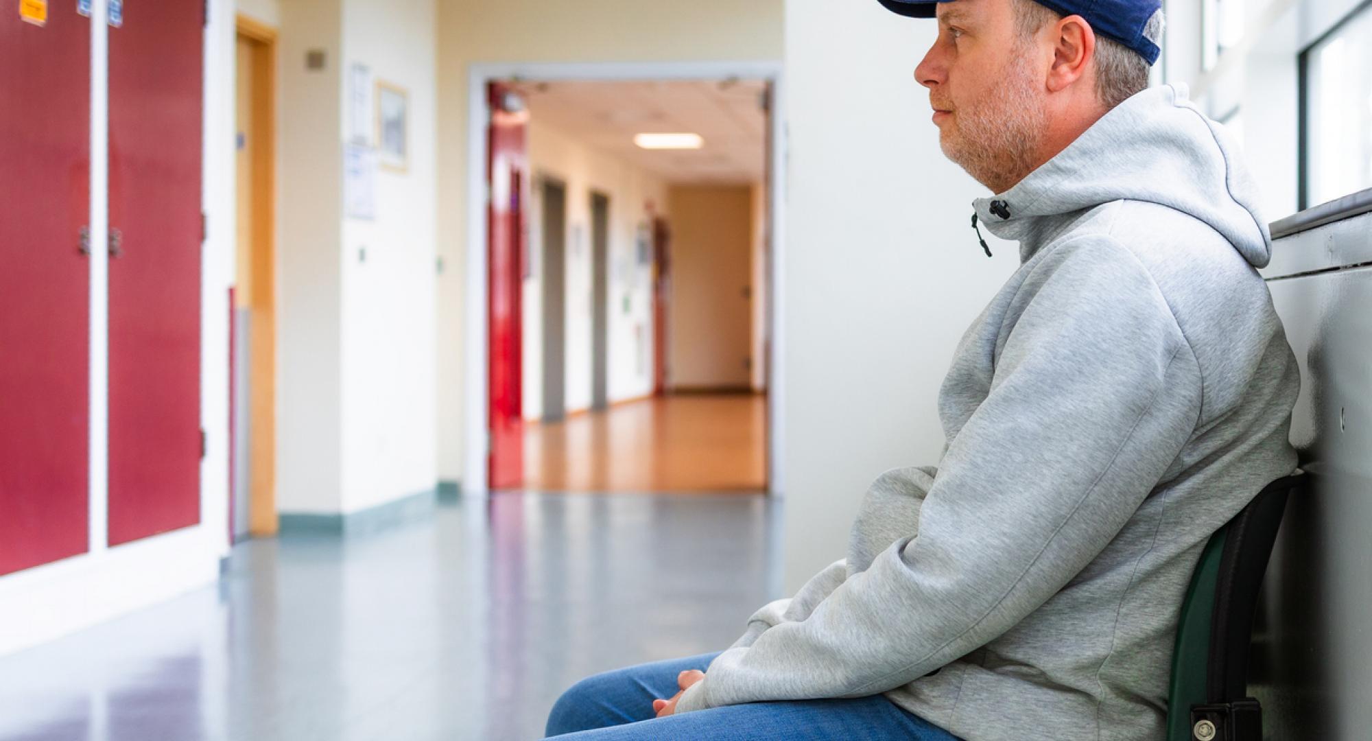 Man sat in a hospital corridor