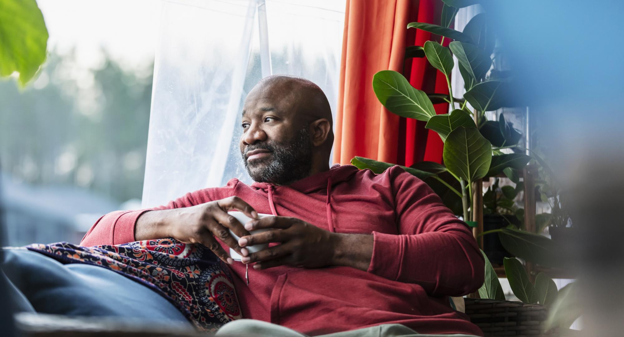 A black man sat on a sofa