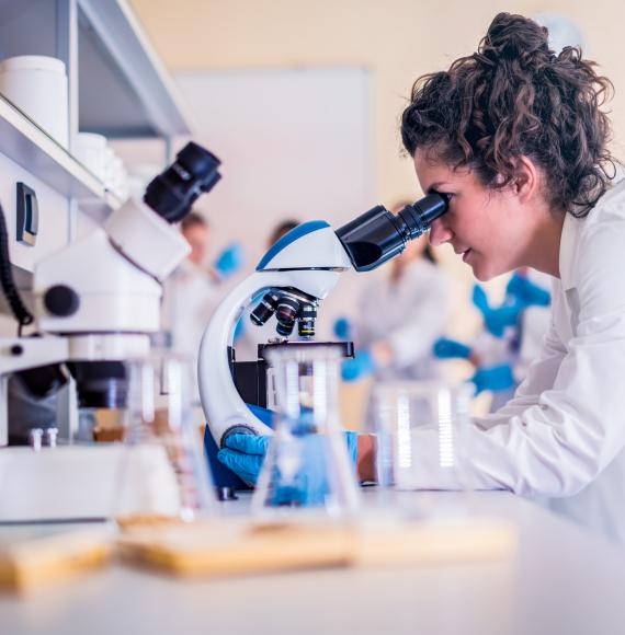 Female scientist looking into microscope