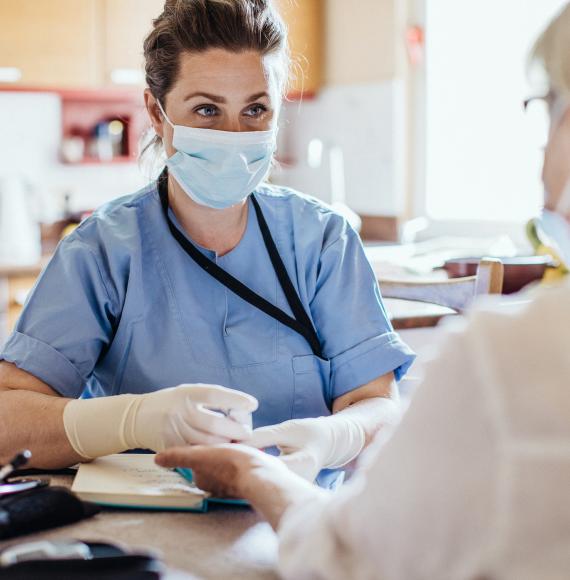 Female nurse in mask providing care in the community