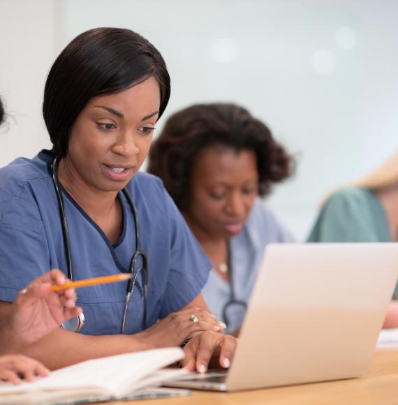 Female nurses studying at laptop