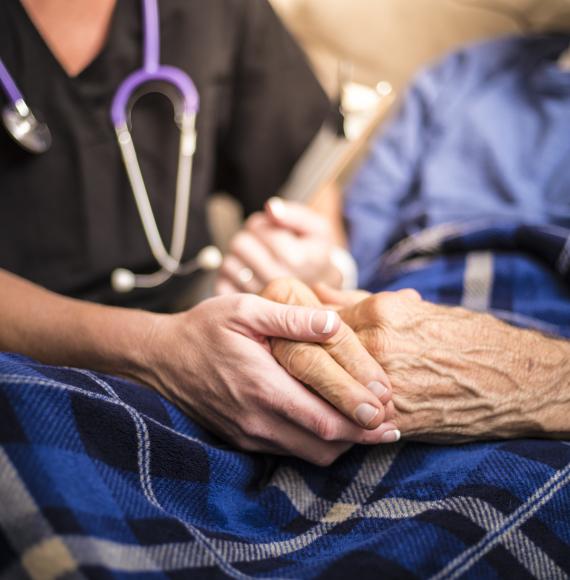 Nurse holding hand of elderly patient