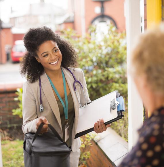 Female doctor visits elderly patient at home. 