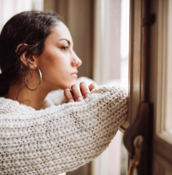 Young woman looking out of a window