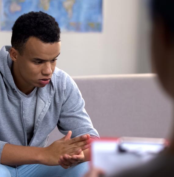 Male teenager discussing his mental health during therapy session