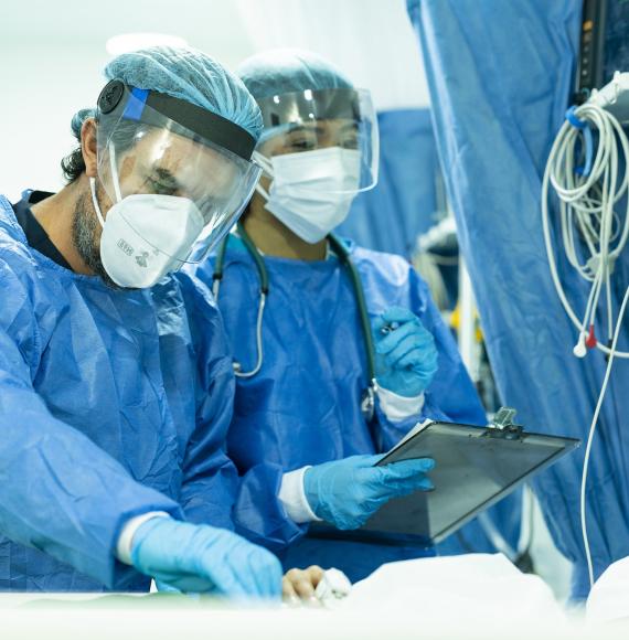 Team of two doctors seeing an inpatient in full protective equipment