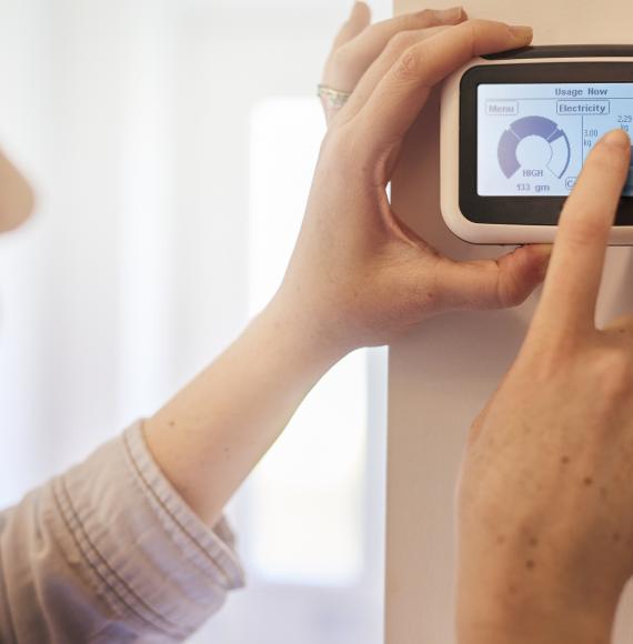 Woman checks smart meter in her home.