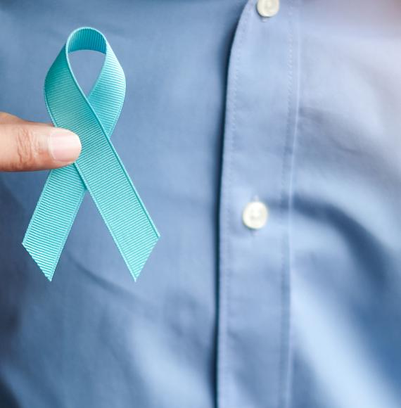 Man holding a blue prostate cancer ribbon