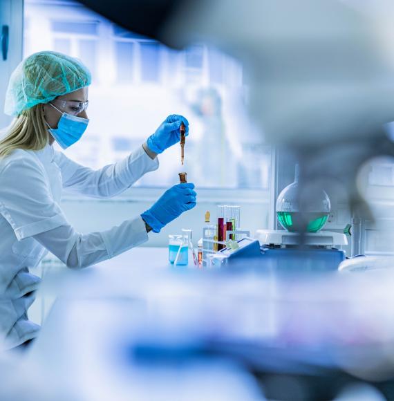 Lab technician working; soft focus photo through lab equipment