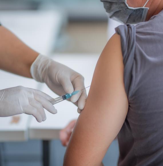 Medical professional administering a vaccine into a patient's arm