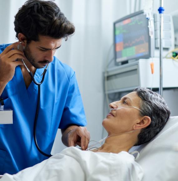 Male health professional listening to a patient with a stethoscope