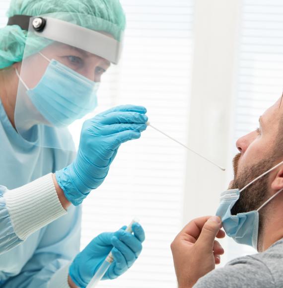 Doctor in PPE swabbing a patient during a test